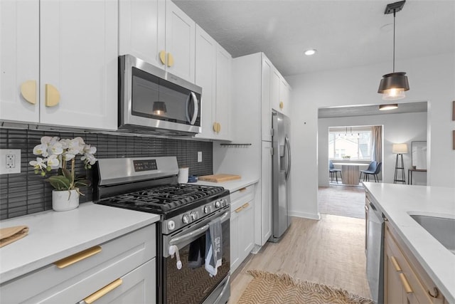 432 Iberia St, Mt Washington, PA 15211 - kitchen with appliances with stainless steel finishes, tasteful backsplash, light countertops, white cabinetry, and light wood-style floors