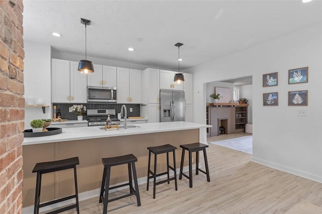 432 Iberia St, Mt Washington, PA 15211 - kitchen featuring appliances with stainless steel finishes, a sink, decorative backsplash, a kitchen breakfast bar, and light countertops