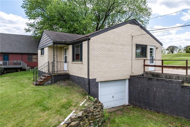 view of side of home featuring an attached garage and a yard