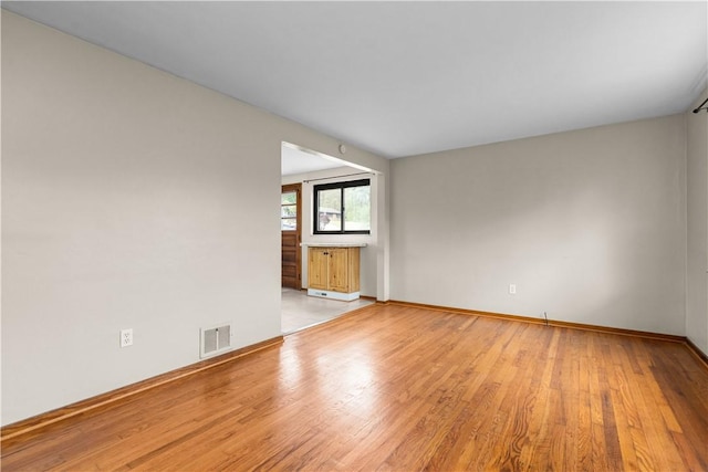 empty room with light wood-style flooring and baseboards