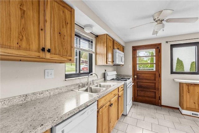 kitchen featuring white appliances, a sink, plenty of natural light, and light countertops