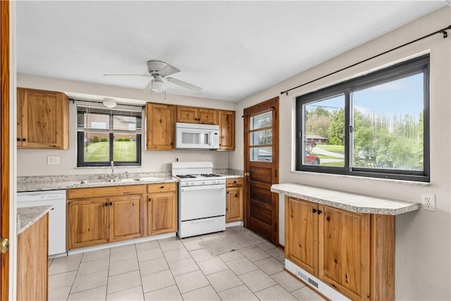 kitchen featuring white appliances, a sink, healthy amount of natural light, and ceiling fan