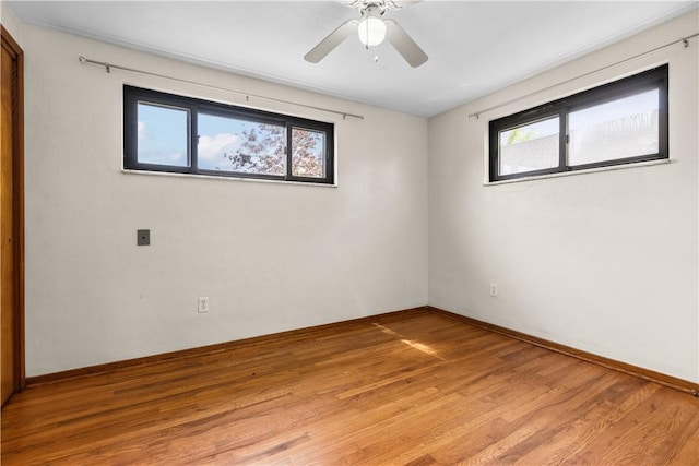 spare room with healthy amount of natural light, light wood-style floors, ceiling fan, and baseboards