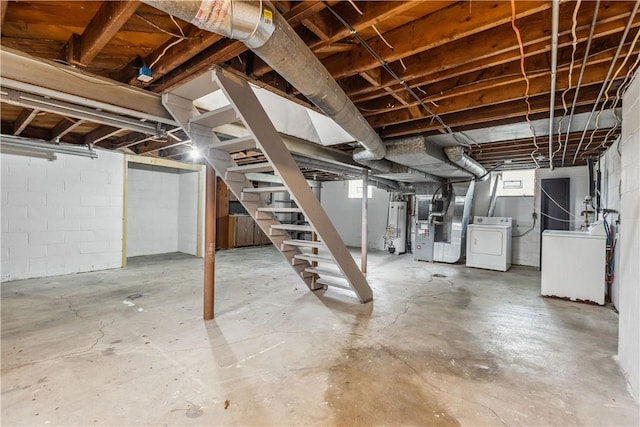 below grade area featuring stairs, heating unit, water heater, and washing machine and dryer