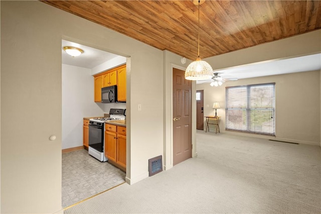 kitchen with gas range oven, black microwave, ceiling fan, baseboards, and wood ceiling