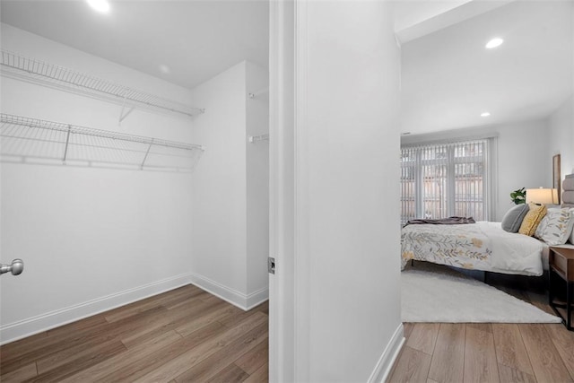 bedroom with wood finished floors, recessed lighting, and baseboards