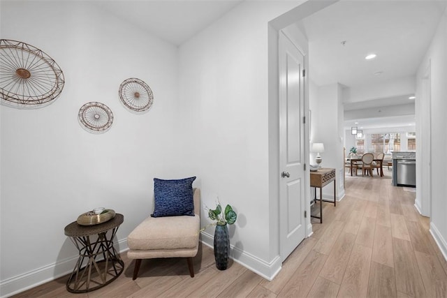 sitting room featuring light wood finished floors, baseboards, and recessed lighting