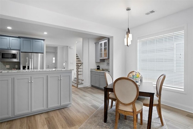 dining room with light wood-style floors, baseboards, stairway, and recessed lighting