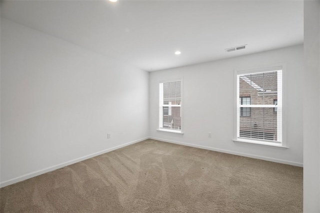 carpeted spare room featuring baseboards, plenty of natural light, and recessed lighting