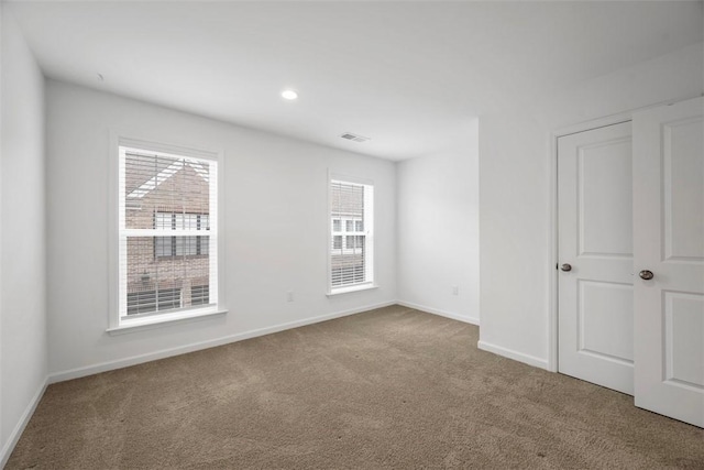 empty room with carpet floors, healthy amount of natural light, baseboards, and recessed lighting