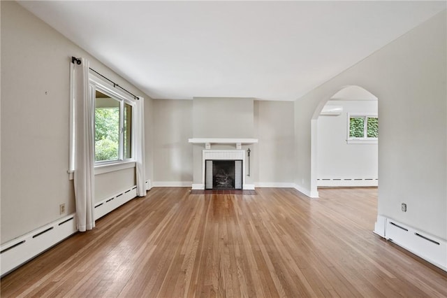6640 Wilkins Ave, Squirrel Hill, PA 15217 - unfurnished living room featuring a baseboard heating unit, hardwood / wood-style floors, a baseboard radiator, and arched walkways