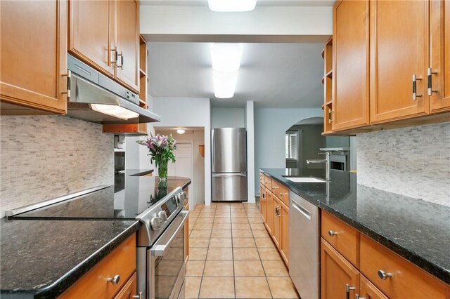 6640 Wilkins Ave, Squirrel Hill, PA 15217 - kitchen featuring open shelves, stainless steel appliances, under cabinet range hood, arched walkways, and light tile patterned floors