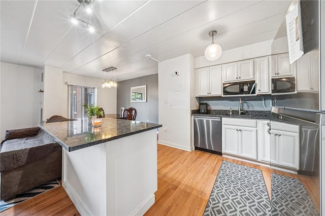 kitchen featuring stainless steel dishwasher, black microwave, a chandelier, and light wood-style flooring