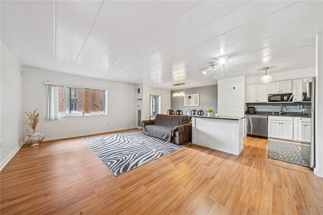 living area featuring light wood-style floors and baseboards