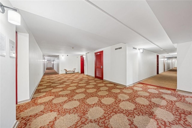 hall featuring carpet flooring and baseboards