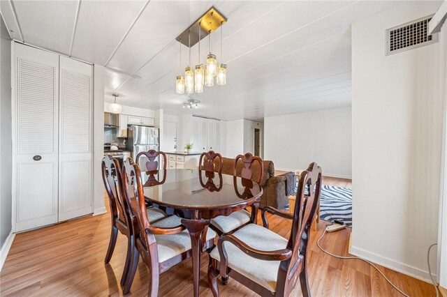 dining space featuring light wood finished floors and baseboards