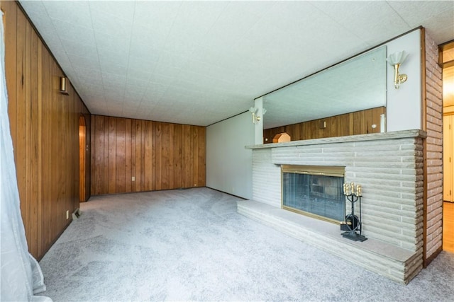 6109 Roy St, Union Twp, PA 15332 - unfurnished living room featuring carpet, wood walls, and a brick fireplace