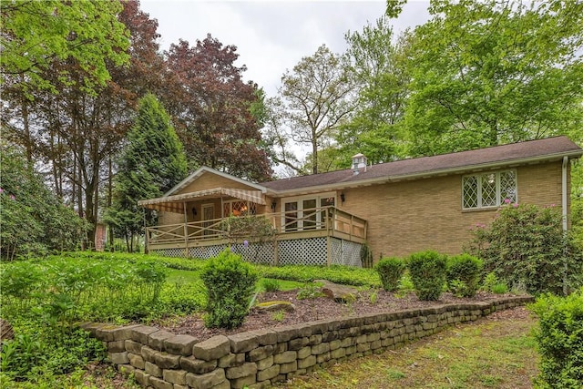 back of property featuring brick siding and a porch