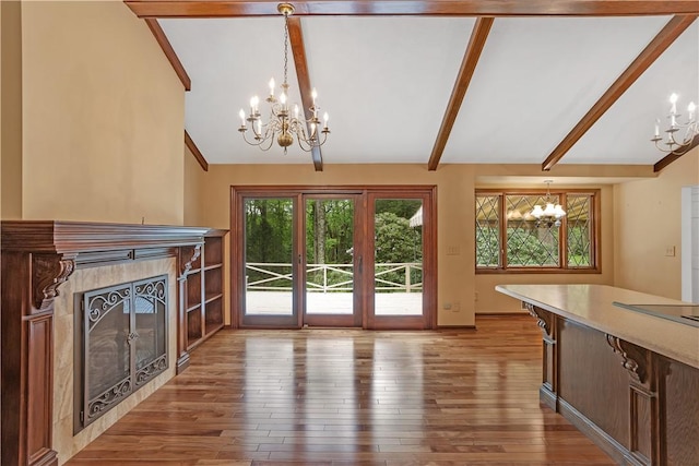 unfurnished living room featuring a chandelier, a fireplace, hardwood / wood-style flooring, and baseboards