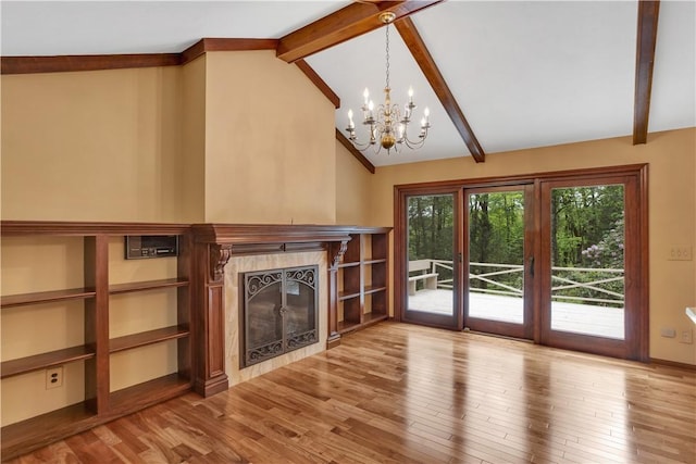 unfurnished living room with a high end fireplace, a chandelier, and wood finished floors