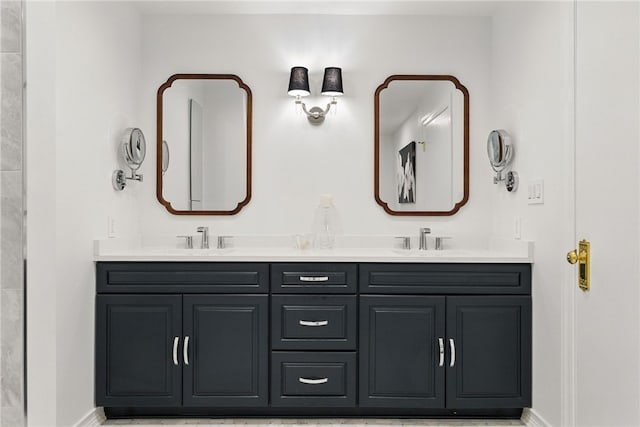 bathroom with baseboards and double vanity