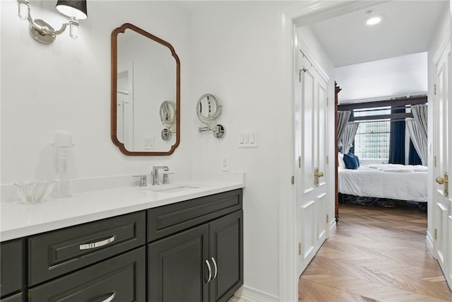 bathroom featuring vanity, connected bathroom, baseboards, and recessed lighting