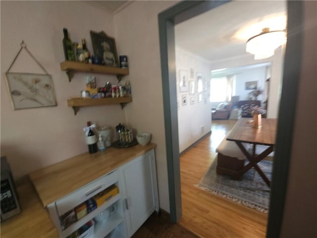 hall with crown molding and wood finished floors