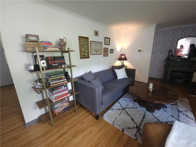 living area featuring ornamental molding and wood finished floors
