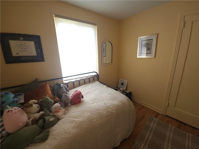 bedroom with wood finished floors and baseboards