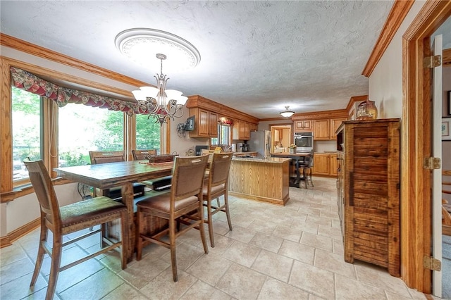 dining space featuring a chandelier, ornamental molding, and a textured ceiling