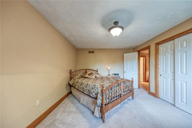 bedroom with baseboards, light colored carpet, and a closet