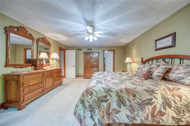 bedroom featuring light carpet, a textured ceiling, baseboards, and ceiling fan