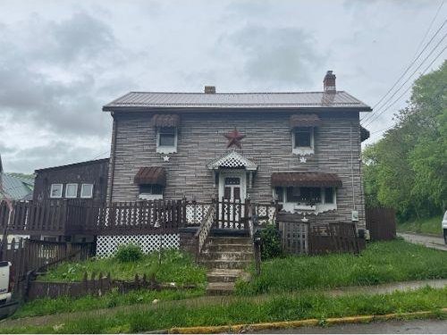 543 Highland Ave, Kittanning Boro, PA 16201 - view of front of home featuring stone siding, a chimney, metal roof, and a wooden deck