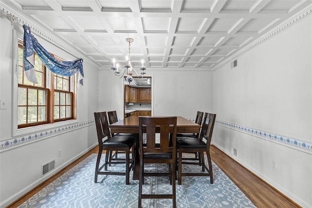 dining room with wood finished floors, a chandelier, baseboards, and coffered ceiling