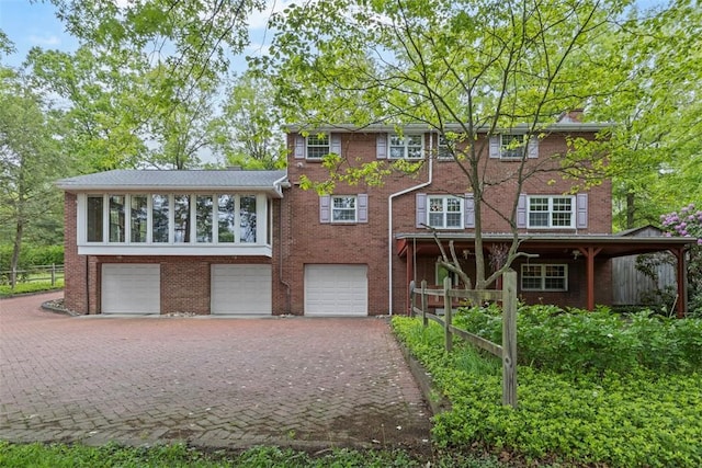 view of front facade with an attached garage, decorative driveway, and brick siding