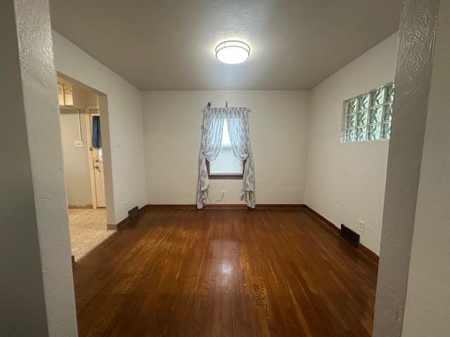 empty room featuring wood-type flooring and baseboards