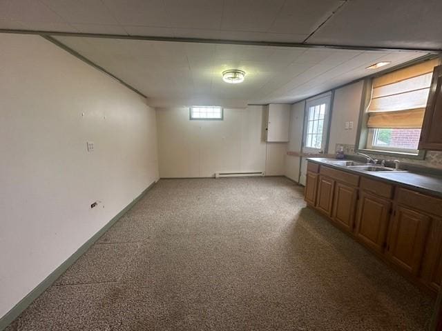 kitchen featuring a sink, a baseboard heating unit, and light colored carpet