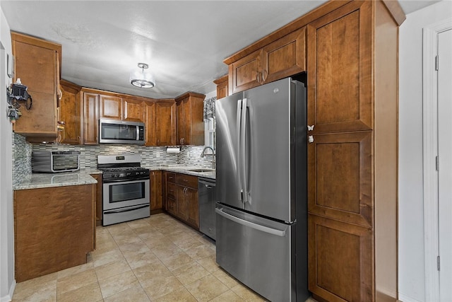 187 Anderson Rd, North Huntingdon, PA 15642 - kitchen with appliances with stainless steel finishes, tasteful backsplash, light stone counters, and brown cabinetry