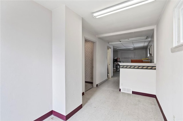 hall featuring baseboards and tile patterned floors
