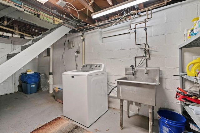 unfinished below grade area featuring washer / dryer and a sink