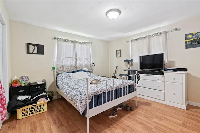 bedroom with light wood-style floors and baseboards