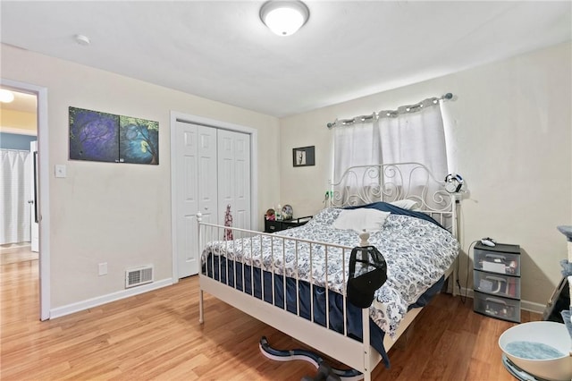 bedroom featuring wood finished floors, baseboards, and a closet