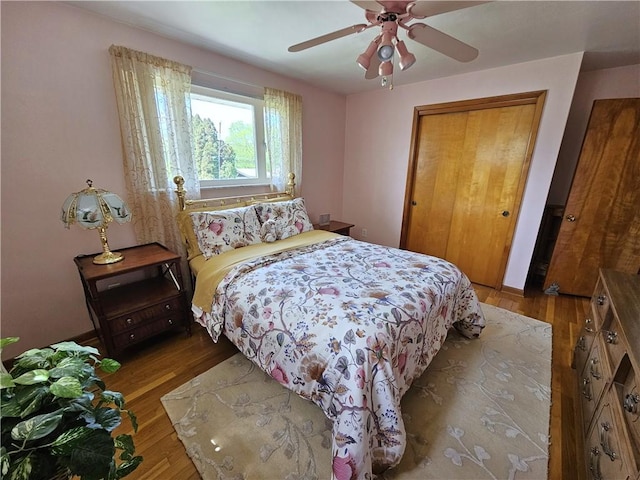 bedroom featuring wood finished floors, a ceiling fan, and a closet