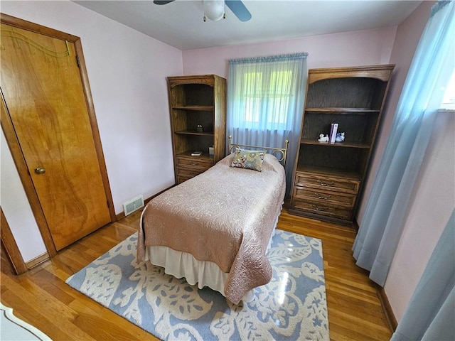 bedroom with wood finished floors, a ceiling fan, and baseboards
