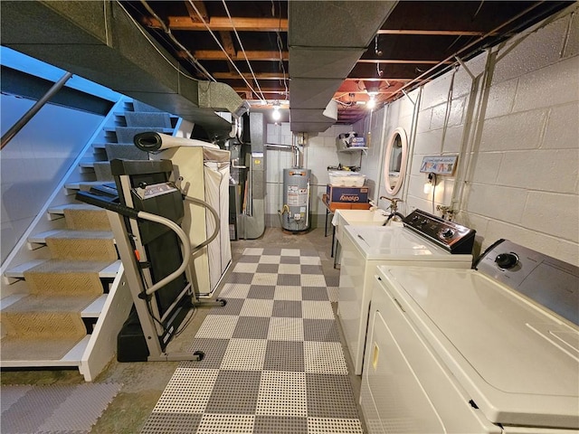 unfinished basement featuring water heater, washer and clothes dryer, concrete block wall, stairway, and heating unit