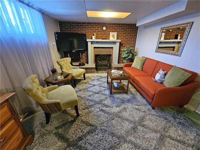 living area with brick wall and a fireplace