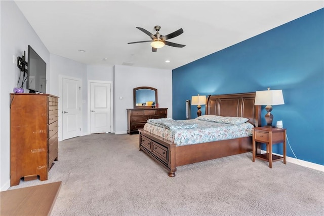 bedroom with light colored carpet, baseboards, and a ceiling fan