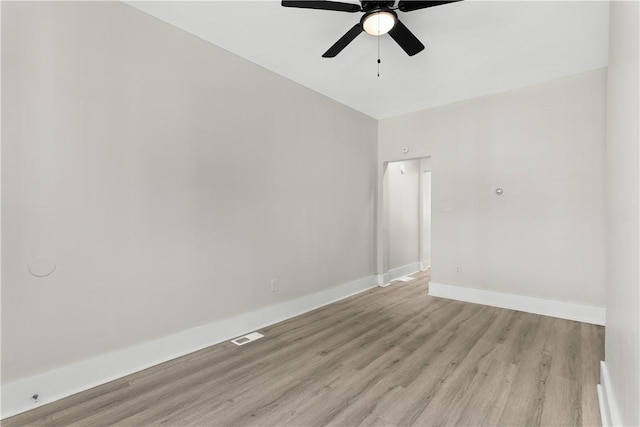 empty room with a ceiling fan, light wood-style floors, and baseboards