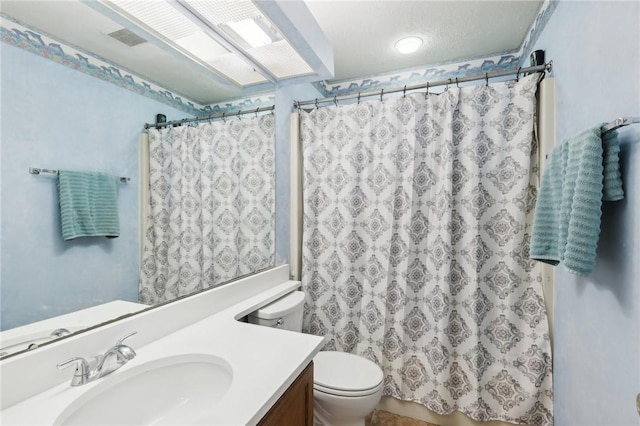 bathroom with toilet, vanity, and curtained shower