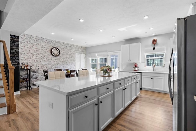 4012 Crown Dr, South Park, PA 15129 - kitchen with freestanding refrigerator, an accent wall, wallpapered walls, a center island, and light wood-style floors